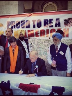 California Governor Jerry Brown (seated) signs AB1964 and SB1540 into law at a rally at the California State Capitol last Saturday. Assembly Member Mariko Yamada (standing left of the Governor), Dr. Onkar Bindra (standing right of the Governor) and Sikh Coalition Advocacy Manager Simran Kaur (far right) joined the Governor. (source: Instagram user i2theb)