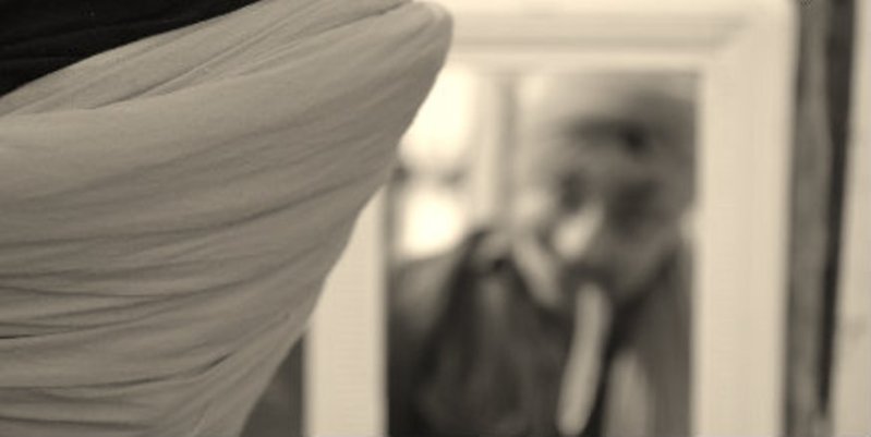 A young Sikh ties his turban in front of a mirror. (adapted photo from Turban King)