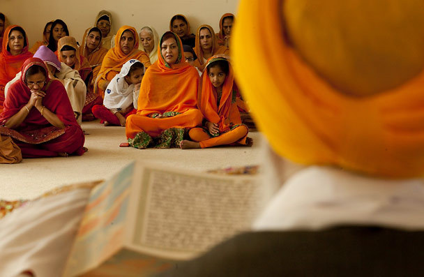 "Attendees listen as the Sikh holy book, Sri Guru Granth Sahib, is read. After readings, from 10 a.m. Friday until 10 a.m. Sunday, Gurudwara members prayed, sang worship songs and played the harmonium and tabla." (source: Erika Shultz / The Seattle Times)