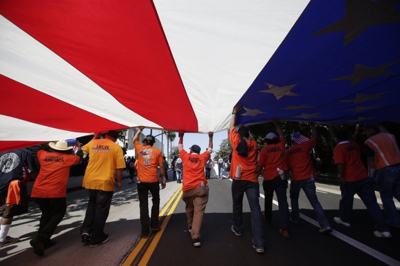 "Union workers march along the street with a huge American flag during a May Day rally in Los Angeles, Wednesday, May 1, 2013. In celebration of May Day, people have gathered across the country to rally for various topics including immigration reform." (Photo credit: AP Photo | Jae C. Hong. Source: OregonLive)