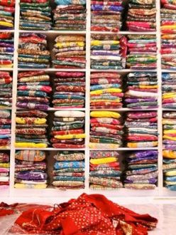 "Harjeet Kaur folds saris while working at her store, Khoobsurat Boutique, in Bothell (Washington) on June 5." (Photo: Genna Martin | The Herald)