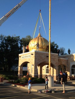 Workers install seven domes now adorn the Sikh Temple of Wisconsin in Oak Creek earlier this month, as tributes to the lives lost in last year's shooting rampage by a white supremacist. (Source: WISN-TV)