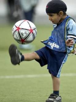 "Harshaan Ahluwalia, 2, dribbles a soccer ball during a friendly soccer match in solidarity with young players who wear turbans Saturday, June 15, 2013 in Montreal. Quebec's soccer federation announced it is ending its much-criticized turban ban Saturday." (Photo credit: Paul Chiasson | THE CANADIAN PRESS. Source: The Globe and Mail.)